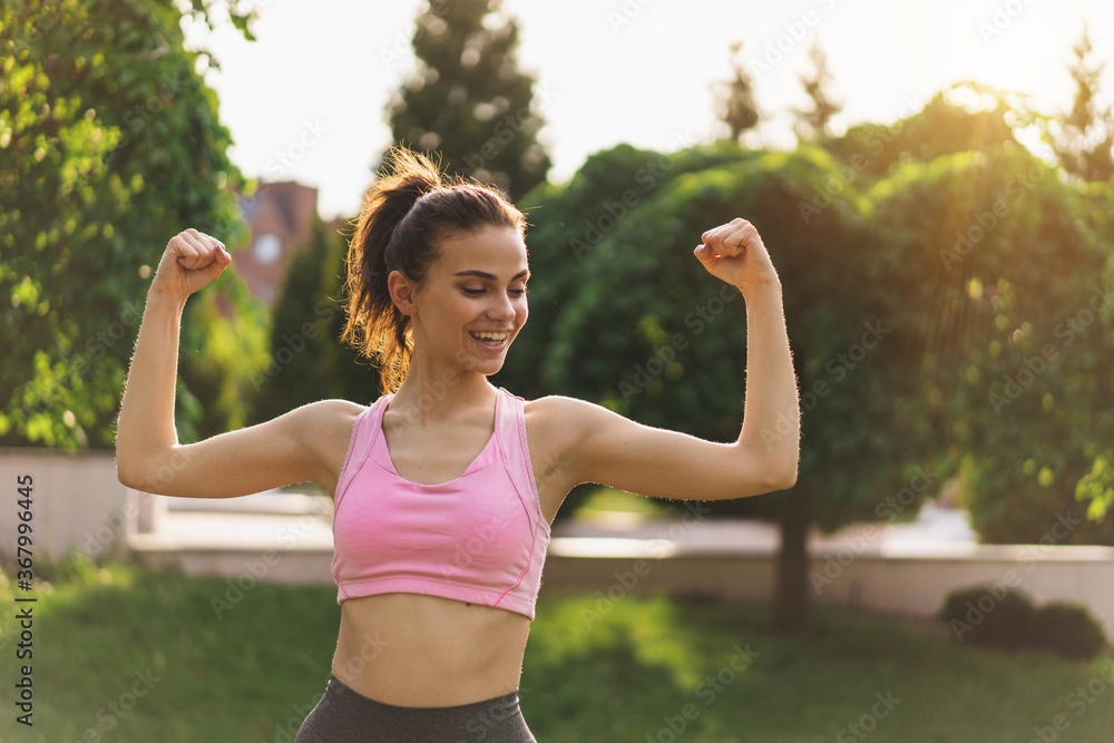 Female model in sportswear showing her muscles. Portrait of young fitness woman flexing muscles and smiling. Female model in sportswear showing her muscles. Portrait of young fitness woman flexing muscles and smiling.