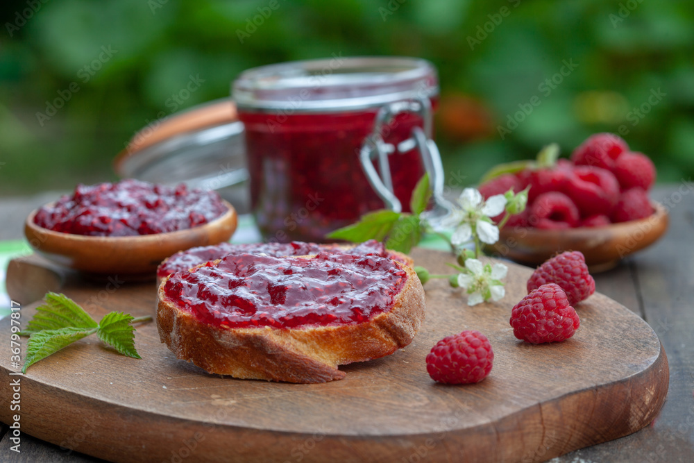 Raspberry jam with fresh raspberries and bread slices on a wooden table. Homemade marmalade, perfect for light, sweet breakfast. Raspberry jam with fresh raspberries and bread slices on a wooden table. Homemade marmalade, perfect for light, sweet breakfast.