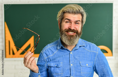 stylish trendy teacher. happy teacher in glasses. check knowledge of student. are you ready for exam test. man tutor in classroom. use math tool and blackboard. back to school. elementary mathematics