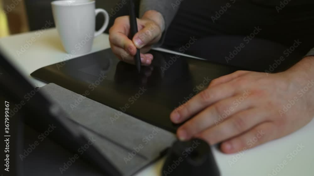 Graphic designer using electronic drawing tablet at home. Graphic designer using electronic drawing tablet at home.
