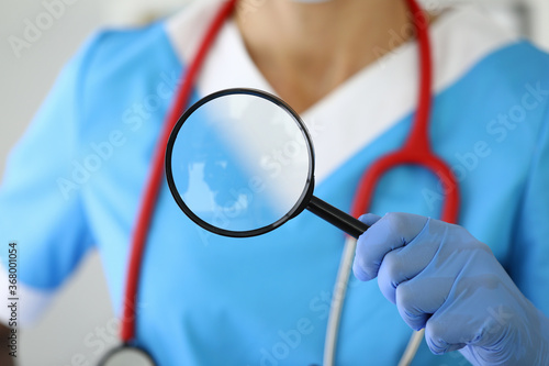Medical researcher holds magnifying glass in his hands. New drug development concept