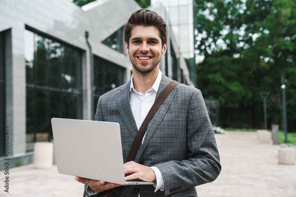 Optimistic handsome business man using laptop Optimistic handsome business man using laptop