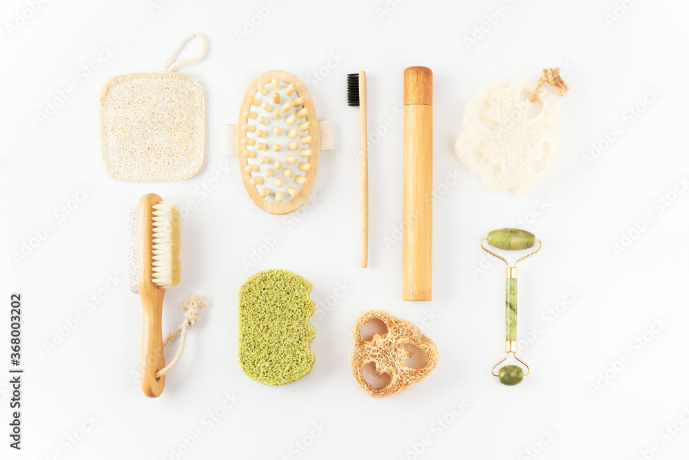 Reusable items for beauty treatment from organic biodegradable material, quartz face roller, anti cellulite massager, bamboo toothbrush, loofah sponge on white surface. Plastic free, ecology concept Reusable items for beauty treatment from organic biodegradable material, quartz face roller, anti cellulite massager, bamboo toothbrush, loofah sponge on white surface. Plastic free, ecology concept