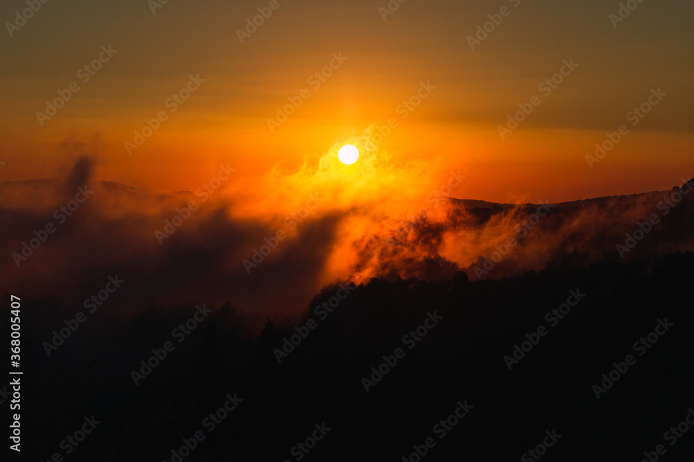 sunset between mountains and fog