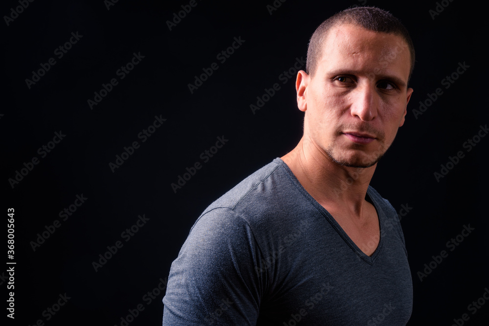 Face of man with short hair against black background
