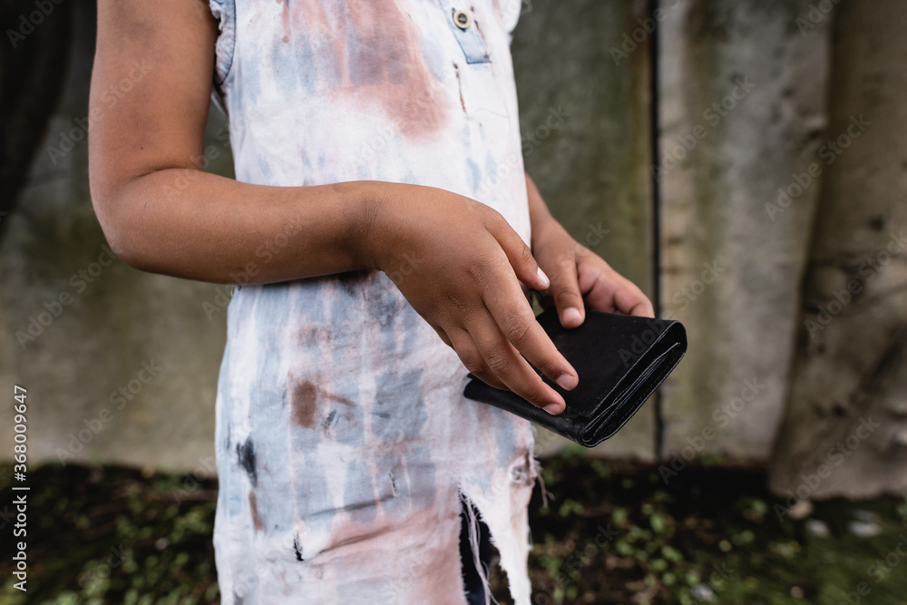 Cropped view of poor african american kid holding wallet on urban street Cropped view of poor african american kid holding wallet on urban street