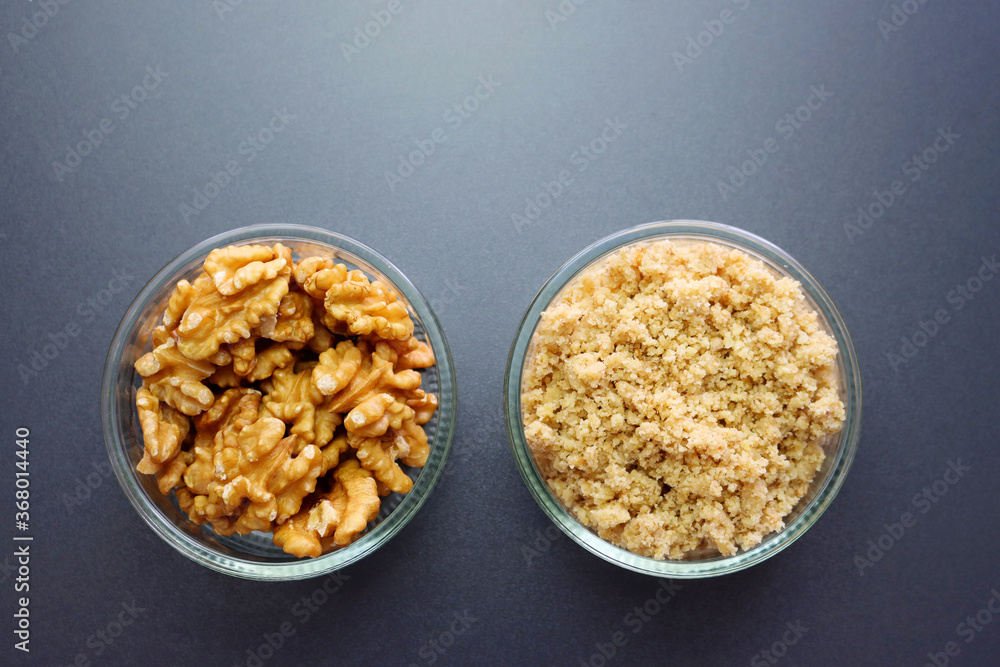 Shelled walnuts and walnut flour. Walnuts on a gray background. Shelled walnuts and walnut flour. Walnuts on a gray background.