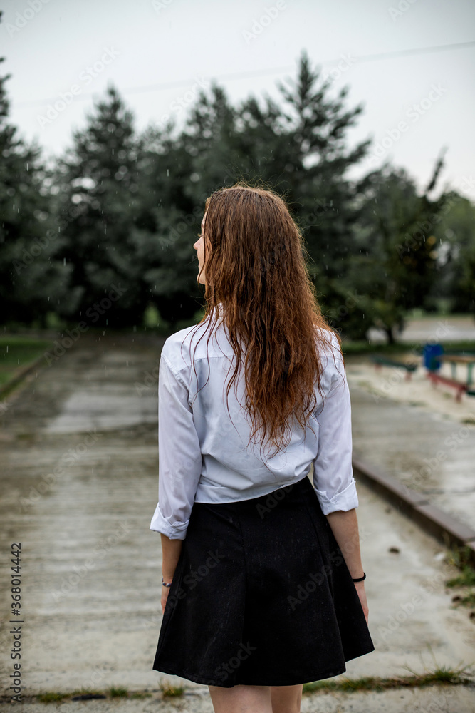 young woman walking on the street in the rain young woman walking on the street in the rain