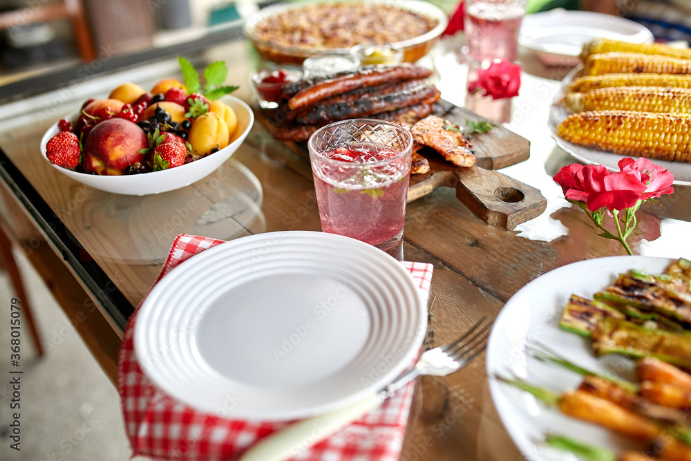 Dinner table with meat grill, roast vegetables, sauces and lemonade, appetizers variety serving on party outdoor table.. Dinner table with meat grill, roast vegetables, sauces and lemonade, appetizers variety serving on party outdoor table..