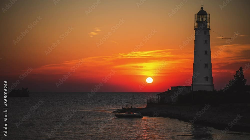 Amazing colourful time lapse sunset at ocean near old Lighthouse and sunken ship Amazing colourful time lapse sunset at ocean near old Lighthouse and sunken ship