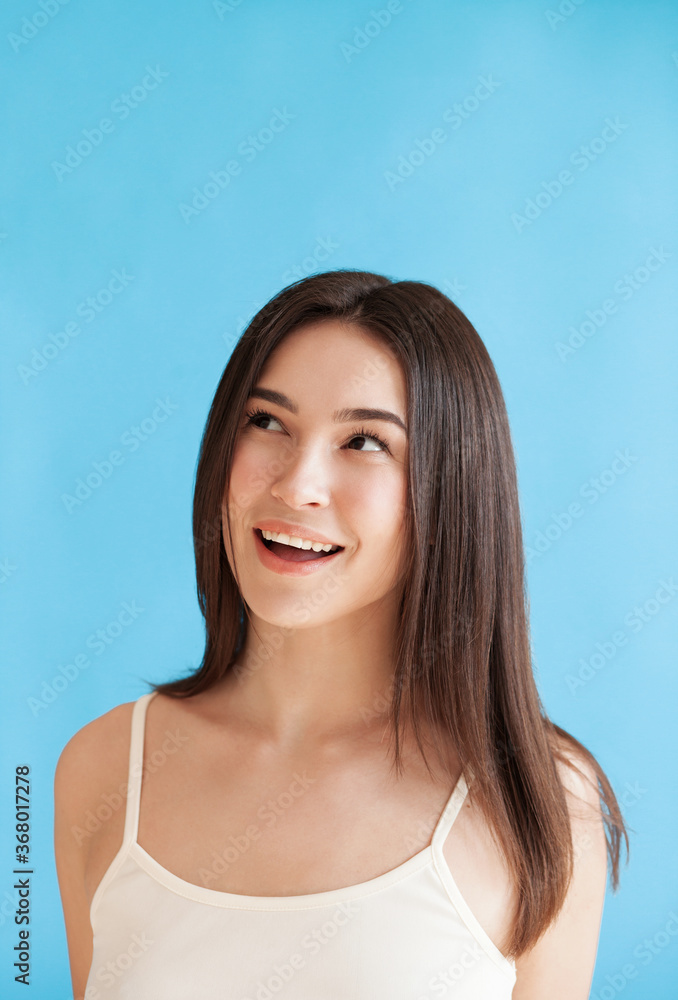 Lovely young woman with healthy smooth skin against blue background Lovely young woman with healthy smooth skin against blue background