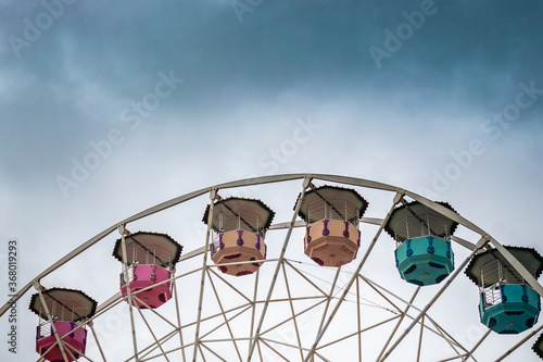 Ferris wheel on cloudy sky background
