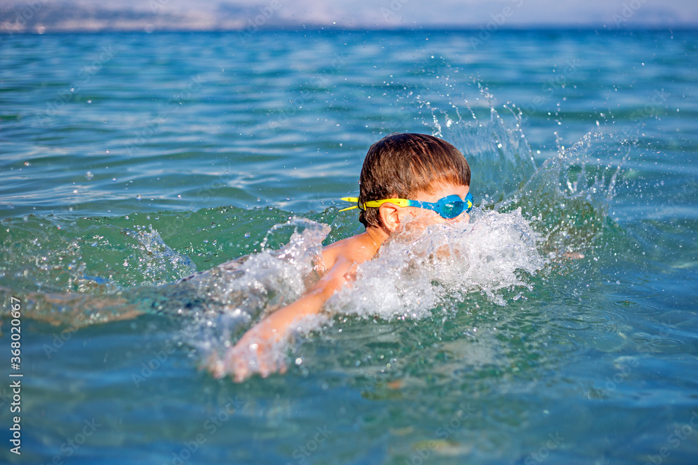 A kid swimming in the sea