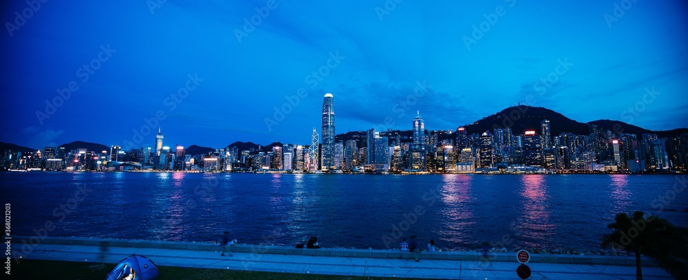 Panoramic shot of a cityscape at night - obrazy, fototapety, plakaty 