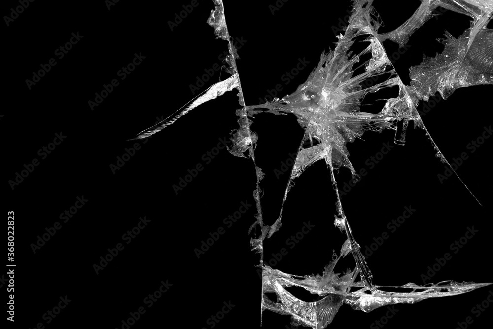 broken mirror glass on a colored and black background in cracks in the form of an isolated image abstraction