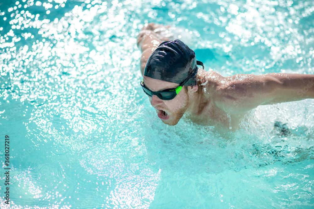 Man in swimming goggles having a workout in pool