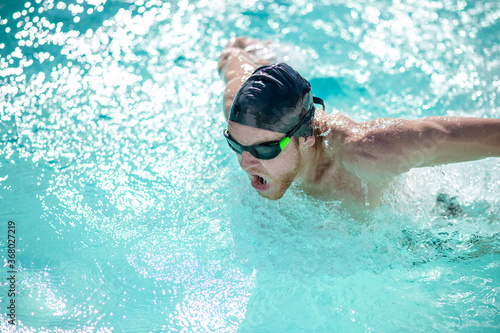 Man in swimming goggles having a workout in pool