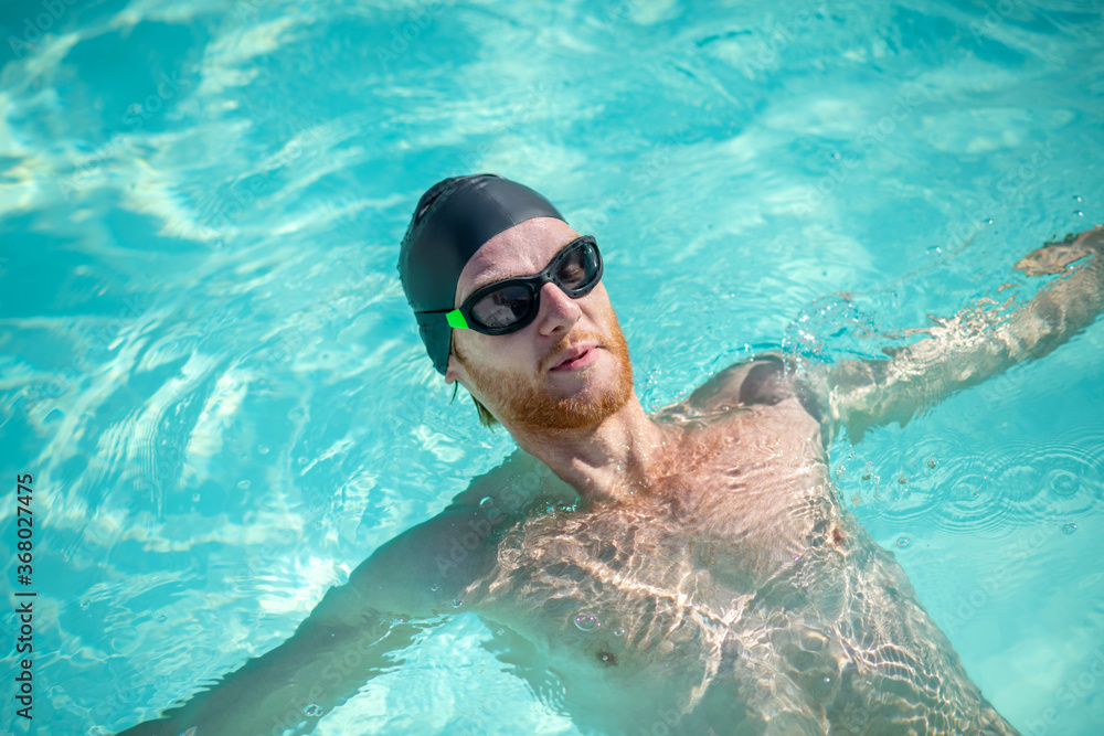 Bearded swimmer lying on his back in water