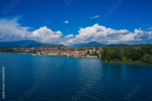 Lazise, Lake Garda, Italy. Aerial view of the historical part of the city in the background cumulus clouds in the blue sky