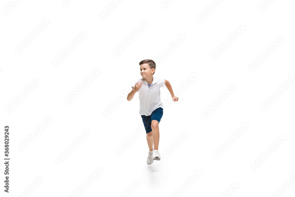 Happy kids, little and emotional caucasian boy jumping and running isolated on white background. Look happy, cheerful, sincere. Copyspace for ad. Childhood, education, happiness concept.