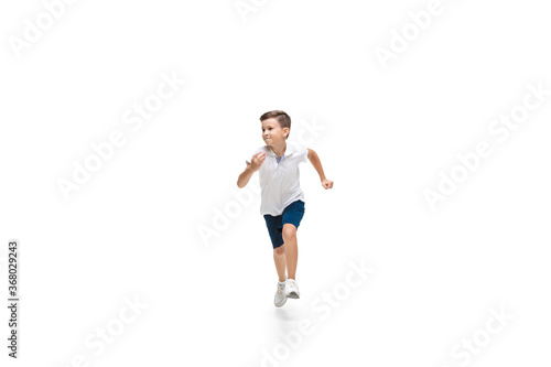 Happy kids, little and emotional caucasian boy jumping and running isolated on white background. Look happy, cheerful, sincere. Copyspace for ad. Childhood, education, happiness concept.