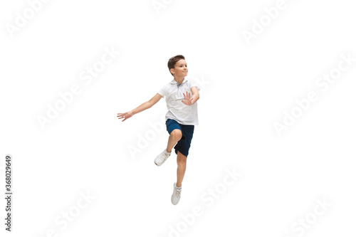 Happy kids, little and emotional caucasian boy jumping and running isolated on white background. Look happy, cheerful, sincere. Copyspace for ad. Childhood, education, happiness concept. © master1305