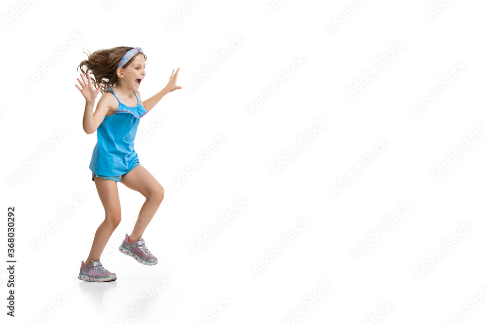 Happy kids, little and emotional caucasian girl jumping and running isolated on white background. Look happy, cheerful, sincere. Copyspace for ad. Childhood, education, happiness concept. Happy kids, little and emotional caucasian girl jumping and running isolated on white background. Look happy, cheerful, sincere. Copyspace for ad. Childhood, education, happiness concept.