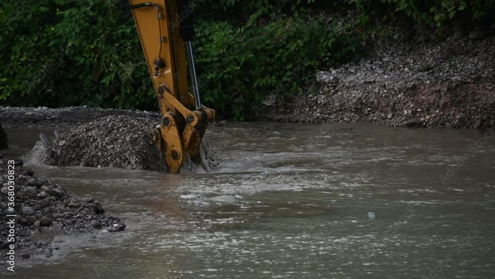 Close up excavator dumps river rocks sand and pebbles. Heavy industry and environment. Ecological disaster. Machine dredging river canal. Dam building. Slow motion, static shot Close up excavator dumps river rocks sand and pebbles. Heavy industry and environment. Ecological disaster. Machine dredging river canal. Dam building. Slow motion, static shot