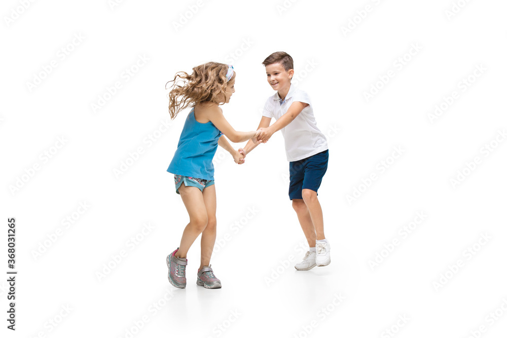 Happy kids, little and emotional caucasian boy and girl jumping and running isolated on white background. Look happy, cheerful, sincere. Copyspace for ad. Childhood, education, happiness concept. Happy kids, little and emotional caucasian boy and girl jumping and running isolated on white background. Look happy, cheerful, sincere. Copyspace for ad. Childhood, education, happiness concept.