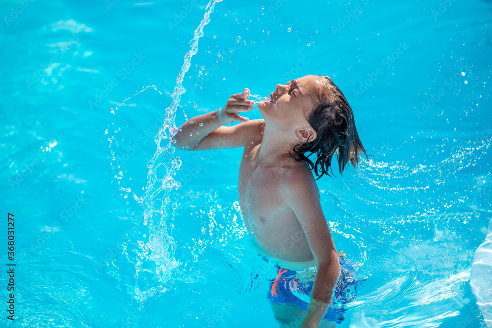 Boy waist-deep in water, throwing his head back