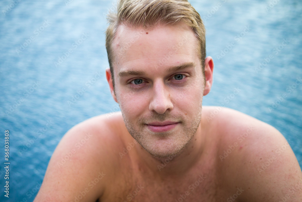 Young handsome shirtless man with blond hair in the swimming pool Young handsome shirtless man with blond hair in the swimming pool