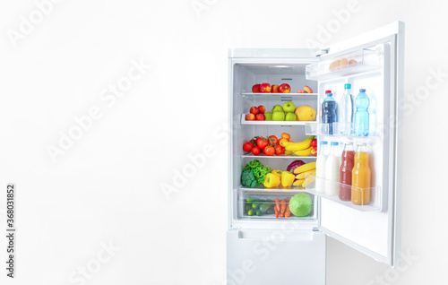 Open fridge full of vegetables and fruits