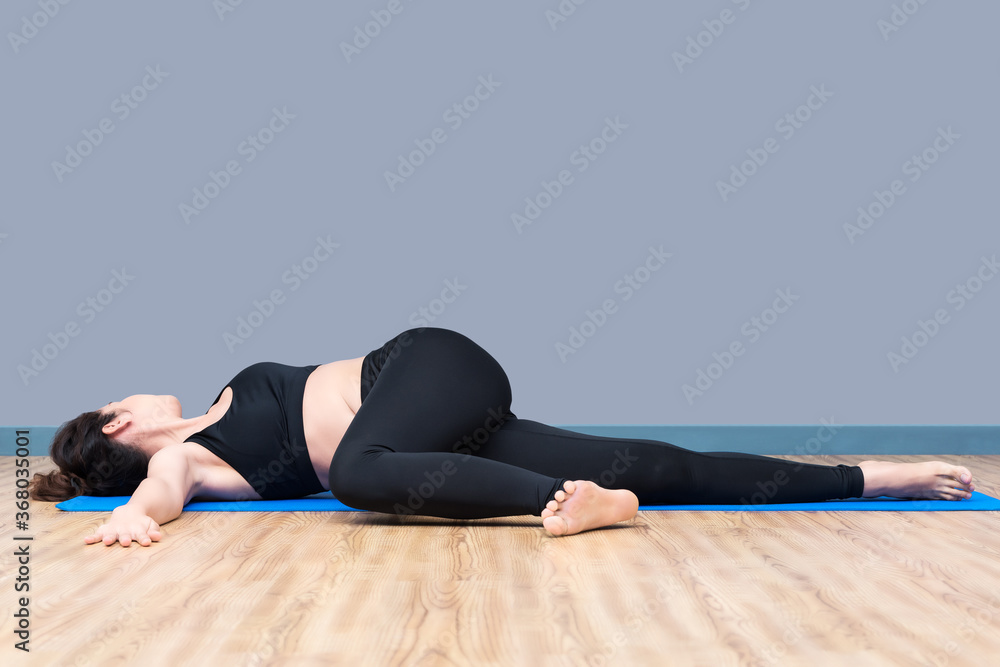 Asian woman practicing yoga pose at yoga healthy sport gym, yoga and meditation have good benefits for health
