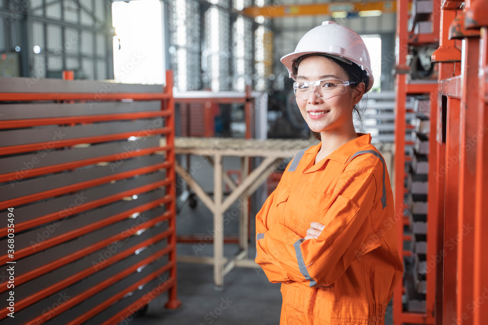Portrait female engineer standing in factory. Portrait female engineer standing in factory.