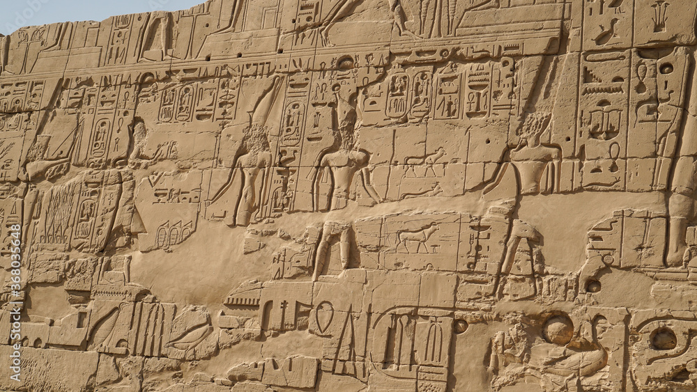 Luxor Egypt karnak temple behind big wall craved with hieroglyphics of god and pharaoh large size