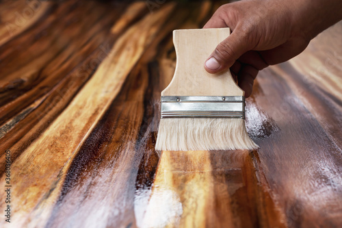 Painter uses paint plots to coat wood for beauty. photo