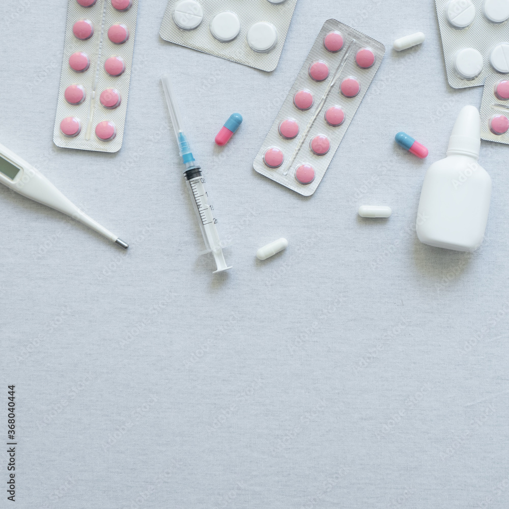 top view of thermometer, pills and nasal spray on white background top view of thermometer, pills and nasal spray on white background