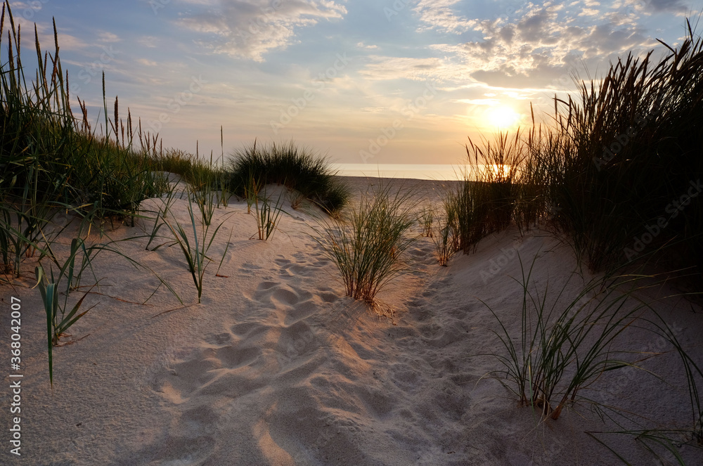 Zachód słońca ,plaża w Kołobrzegu,biały piasek,wydmy na wybrzeżu Morza Bałtyckiego.