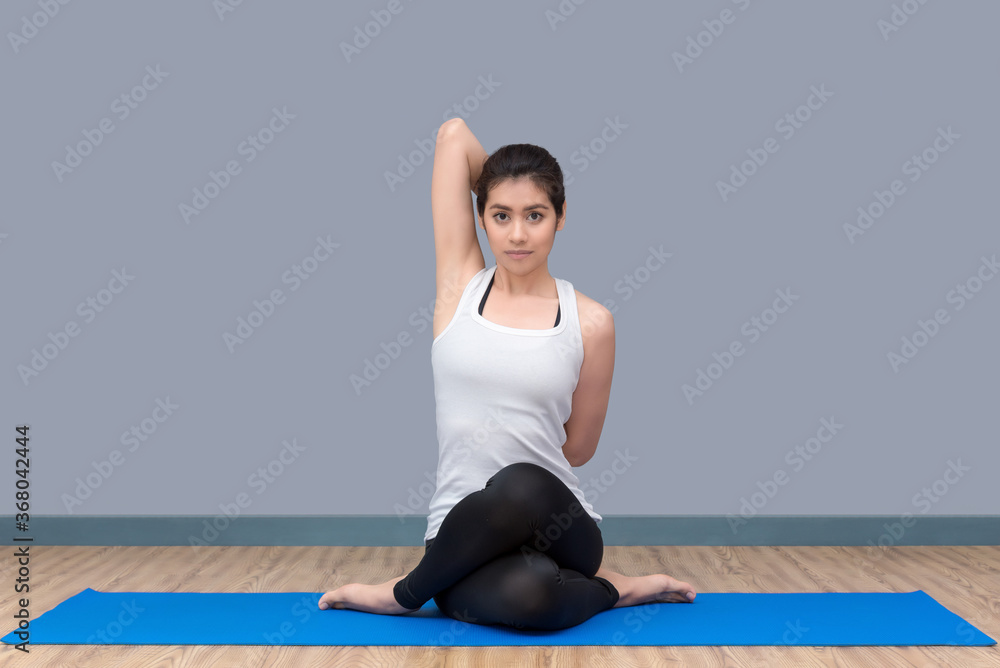 Fototapeta premium Asian woman practicing yoga pose at yoga healthy sport gym, yoga and meditation have good benefits for health