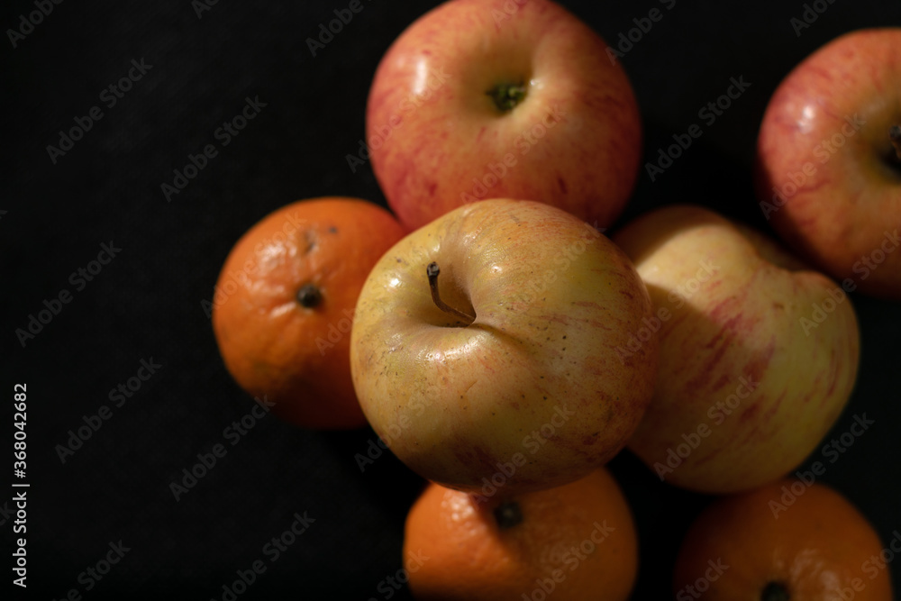 Apple and orange on black background Apple and orange on black background