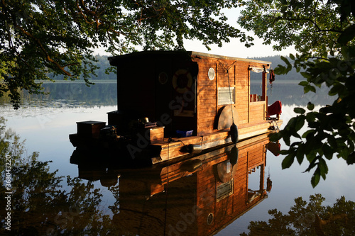 Wooden houseboat at sunrise at Mecklenburger lake district          photo