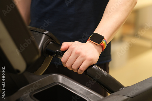 close up man's arm wearing smart watch, exercising on treadmill. blur background