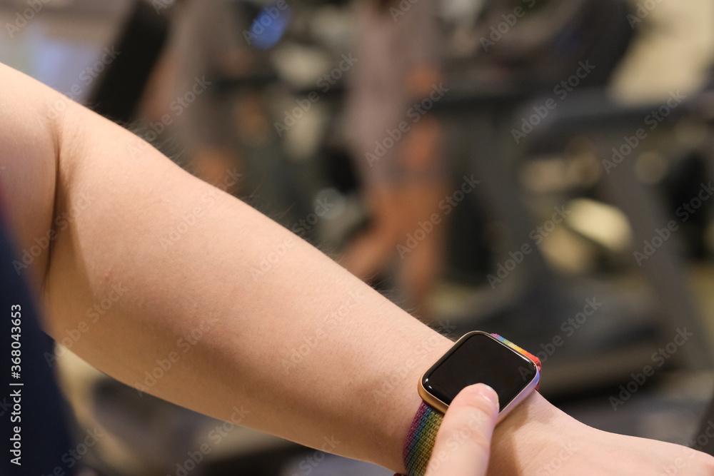 close up man's finger touching blank screen smart watch in gym. blur background close up man's finger touching blank screen smart watch in gym. blur background