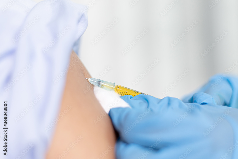 Doctor is vaccinating against Asian men in the hospital.