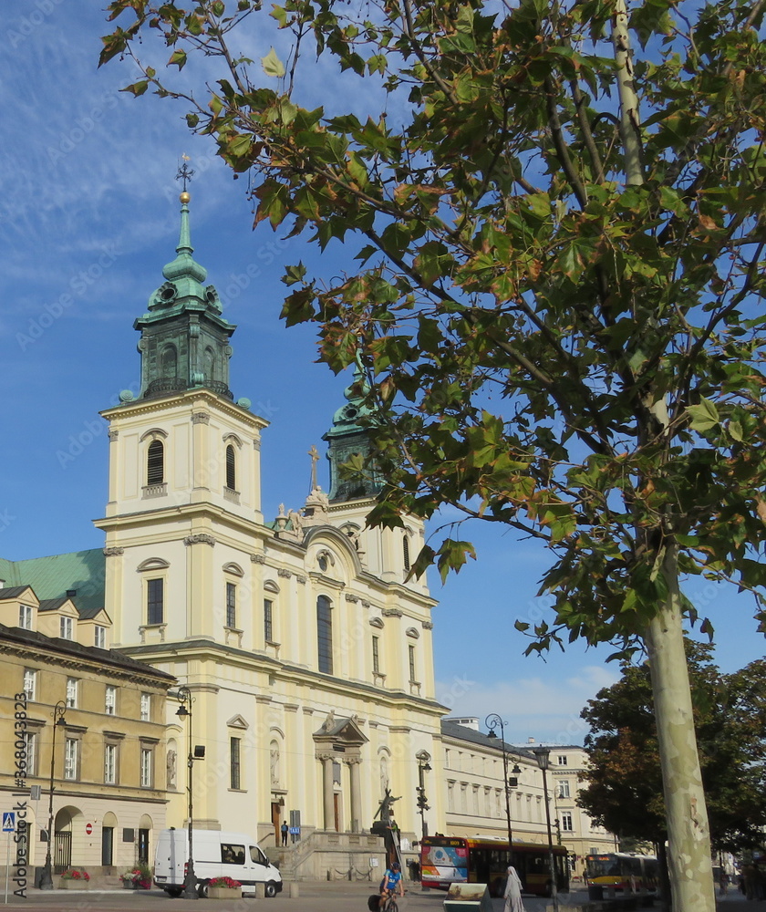 Warsaw, Poland: Copernicus Square on a background of green tree and a building with a cathedral with crosses in the early morning