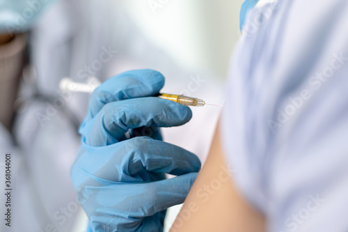 Doctor is vaccinating against Asian men in the hospital.