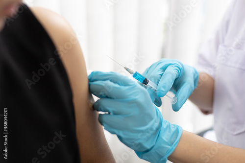 Doctor is vaccinating against Asian men in the hospital.