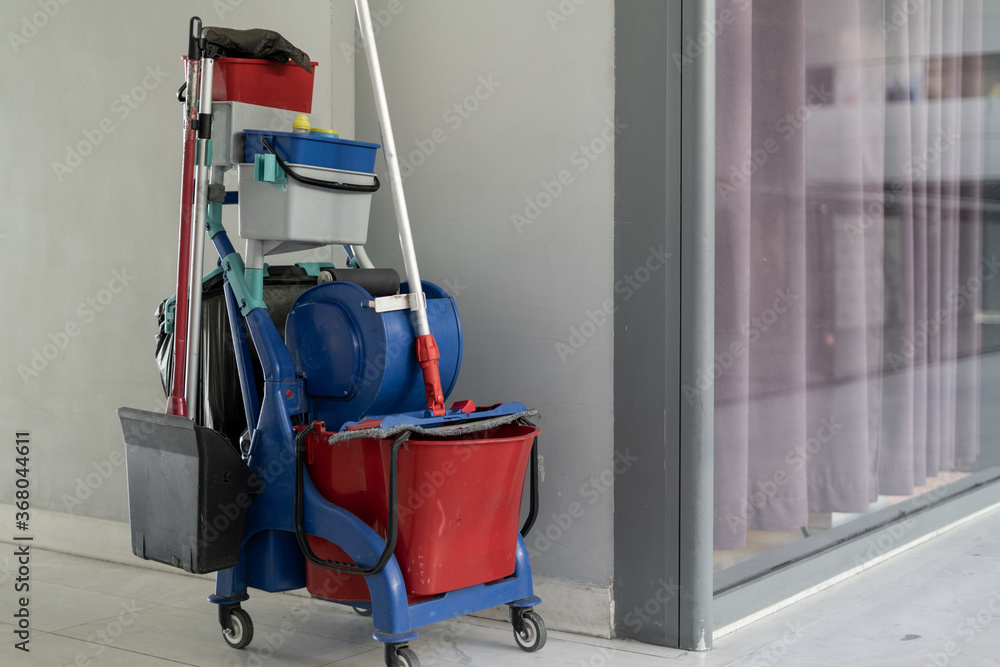 The trolley cleaning tools are waiting to be cleaned. Bucket and a set of cleaning equipment in a shopping center. . Indoor cleaning concept during coronavirus The trolley cleaning tools are waiting to be cleaned. Bucket and a set of cleaning equipment in a shopping center. . Indoor cleaning concept during coronavirus