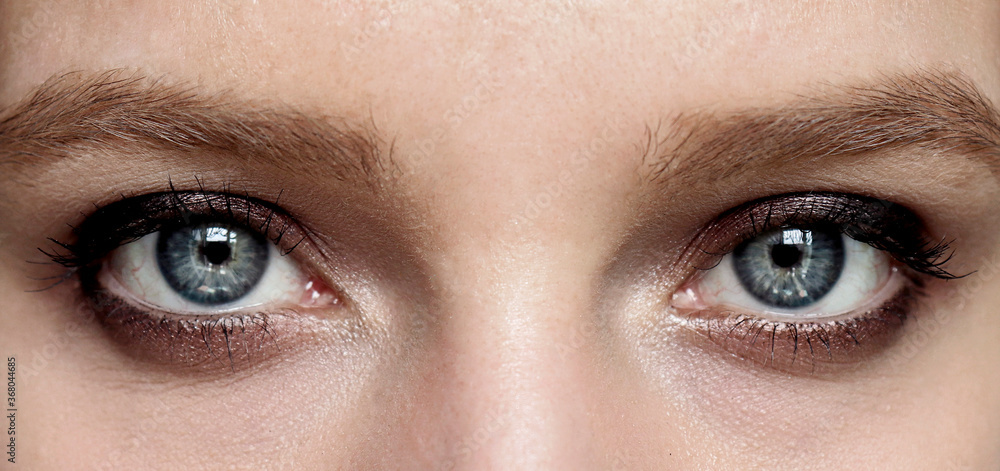 Obraz premium Evening makeup Smokey eyes. Beautiful blue eyes of a girl close-up. Design of a beauty banner.