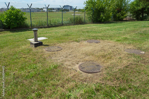 Cast iron sewers among the grass photo